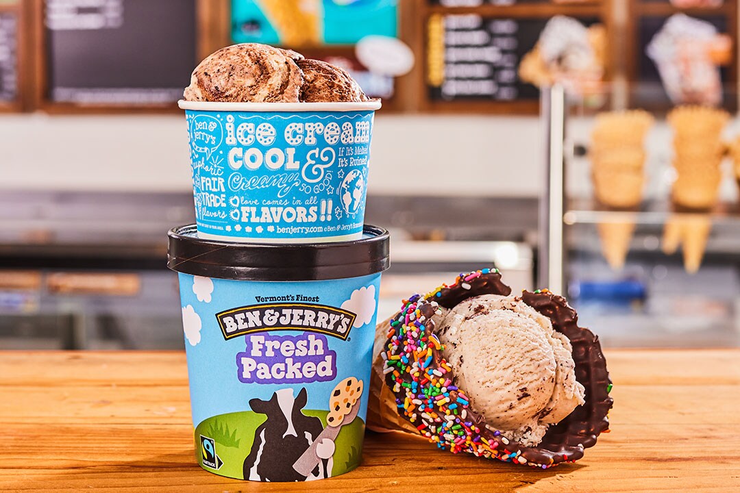 Ice cream pints next to an ice cream waffle cone