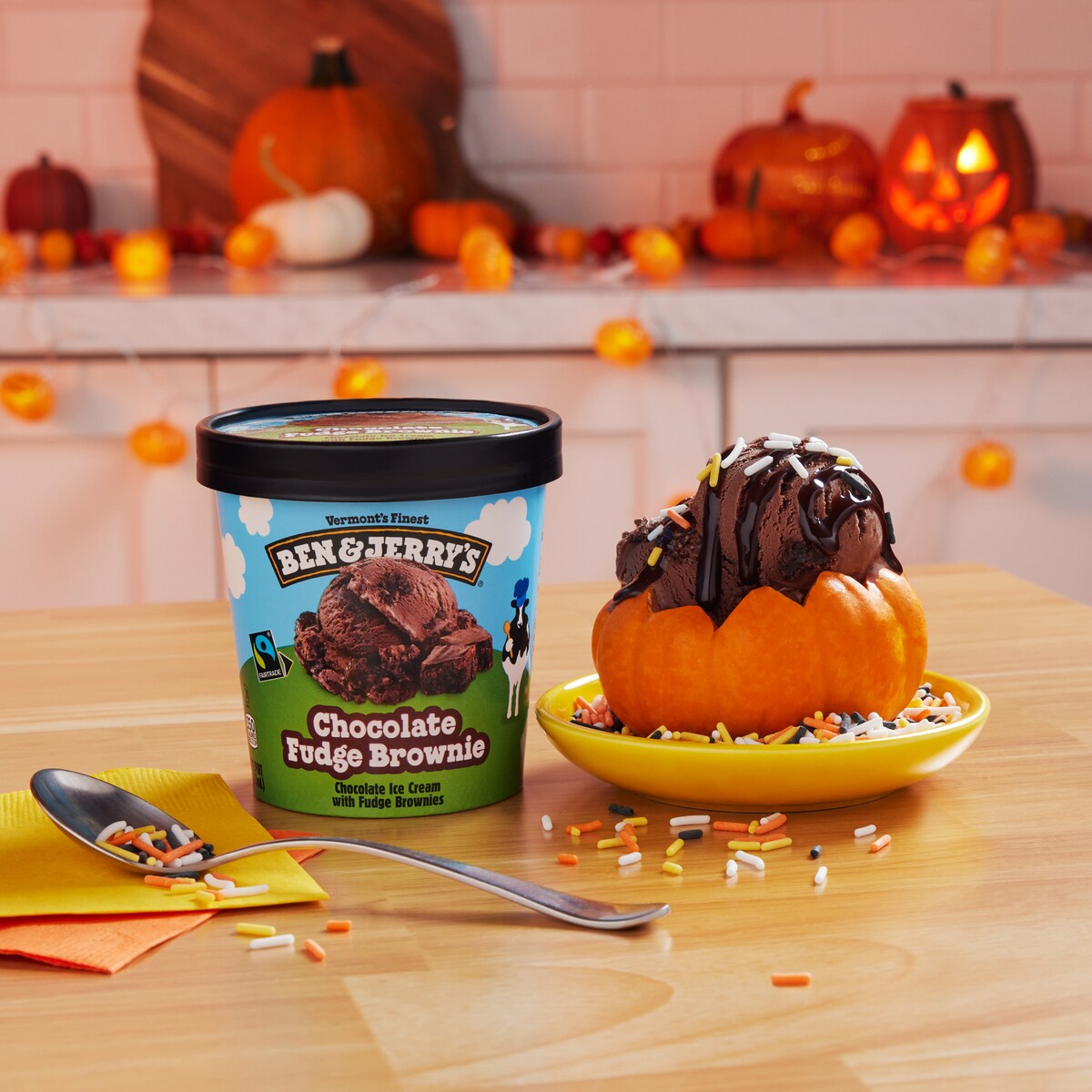 Pint of Ben & Jerry's Chocolate Fudge Brownie ice cream next to a sundae made inside a small carved pumpkin.