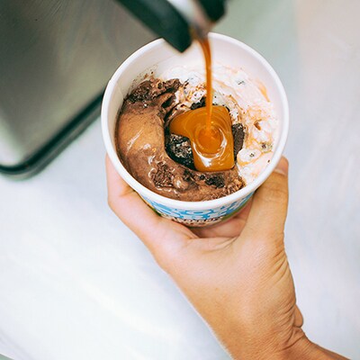 adding some syrup to the cookies in the middle of the ice cream
