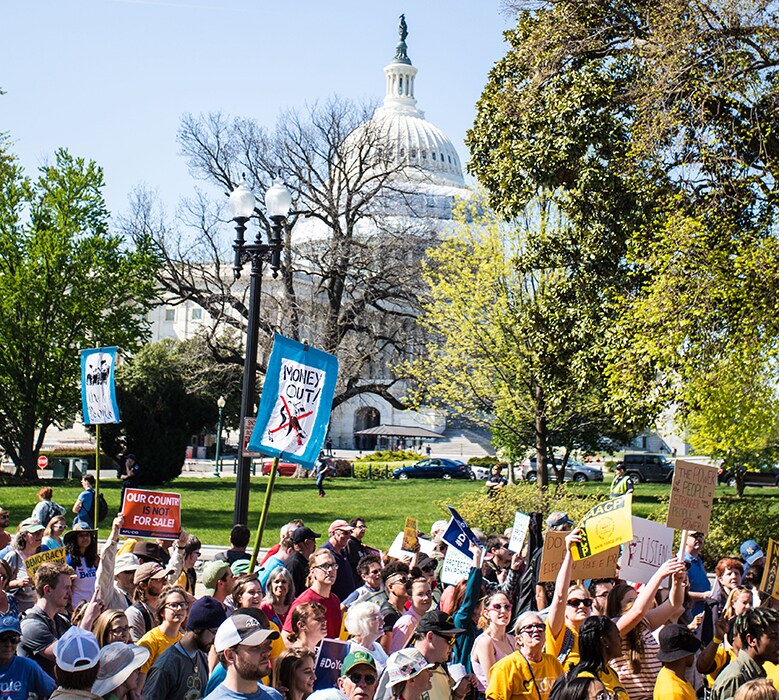 crowd of people with signs by the capitol