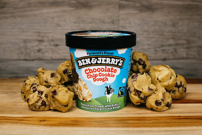 A pint of Chocolate Chip Cookie Dough and dough pieces around it