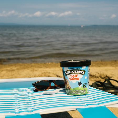 A pint of Ben & Jerry's Half Baked on a lounge chair with ocean view